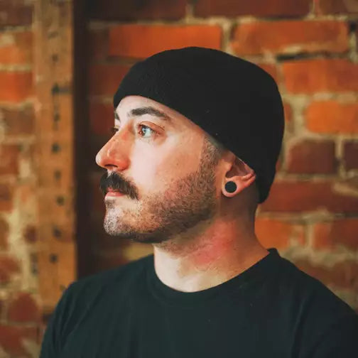 Hombre con gorro negro y barba de perfil, imagen de SHEAR REVIVAL Progress