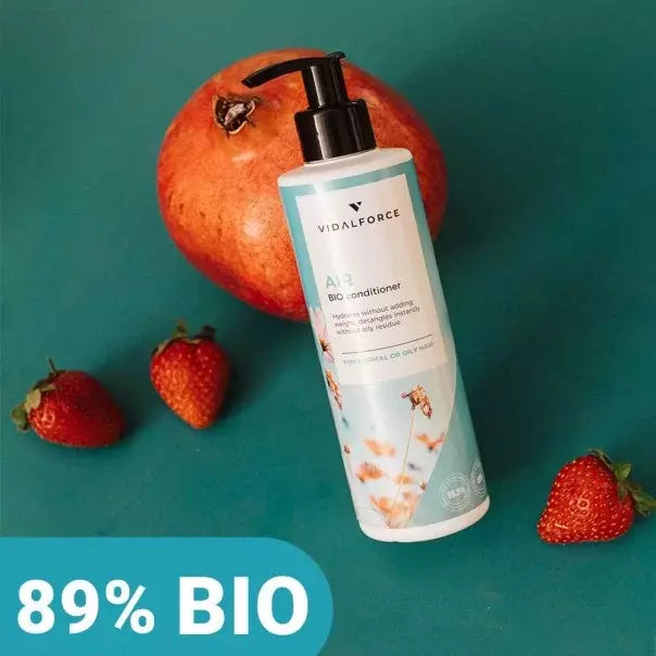 Botella de VIDALFORCE AIR acondicionador sobre una granada y fresas, con sello 89% BIO