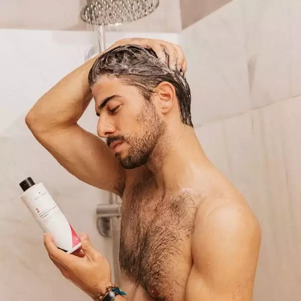 Hombre lavándose el pelo en la ducha con VIDALFORCE champú 2