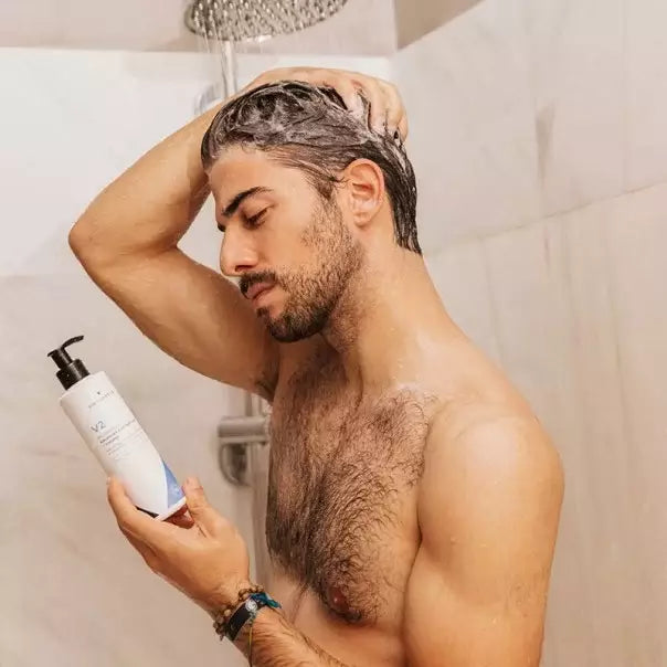 Hombre en la ducha lavándose el pelo con VIDALFORCE champú V2
