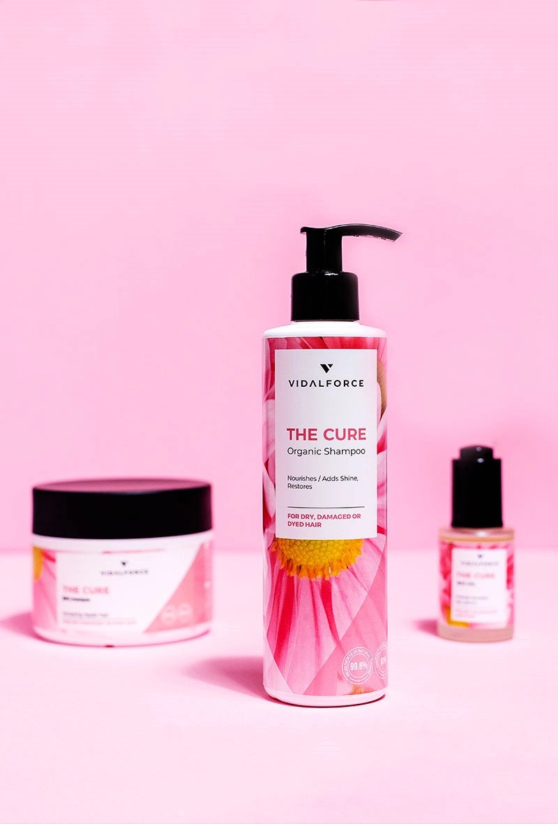 VIDALFORCE THE CURE champú junto a la mascarilla y un frasco sobre fondo rosa