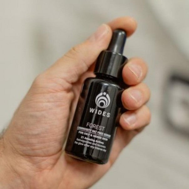 Mano sosteniendo el frasco de WIDES FOREST sérum facial