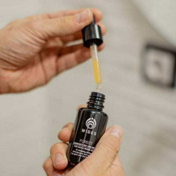 Manos con el cuentagotas de WIDES FOREST sérum facial
