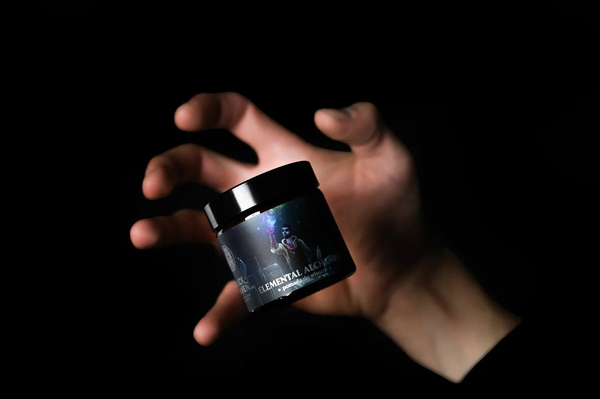 Mano sosteniendo el bote de pomada Elemental Alchemist de BY ELEMENTUM x Slickhaven
