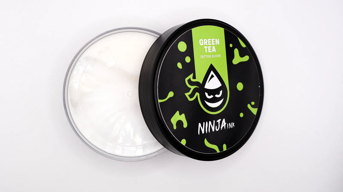 Envase abierto de NINJA INK Tattoo Elixir Green Tea con la crema para tatuajes